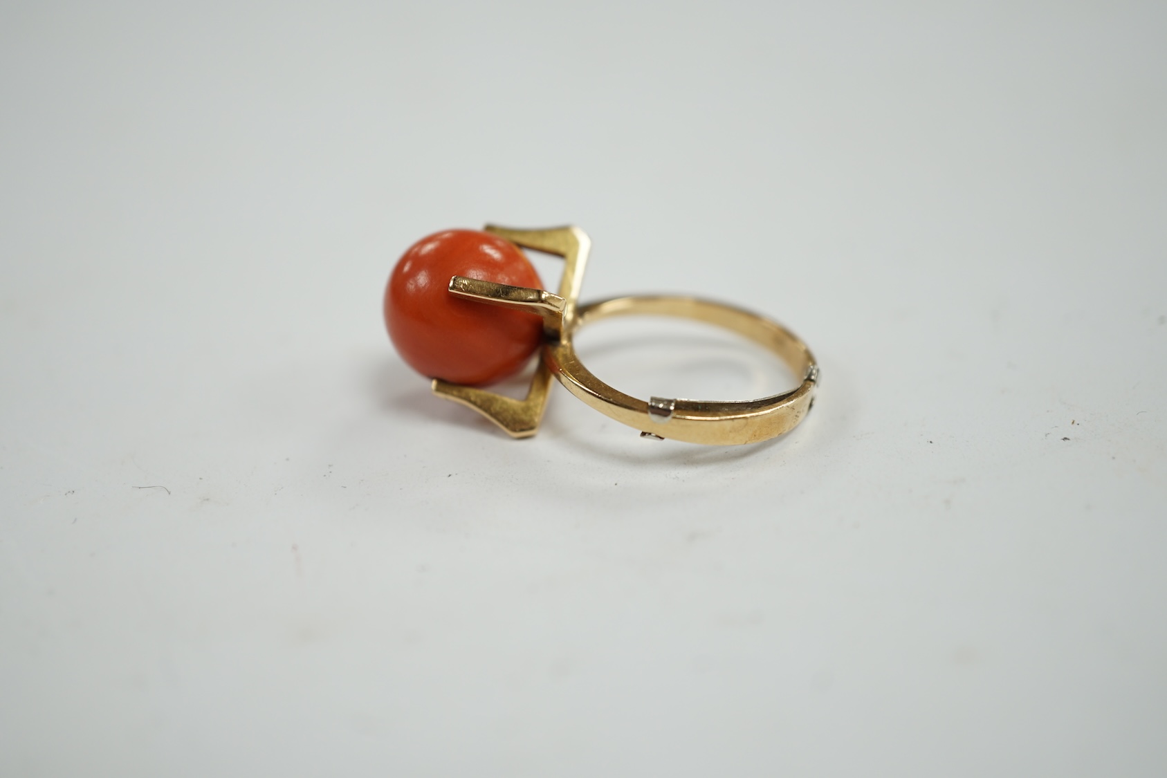 A continental yellow metal and single stone coral bead set dress ring, size O, gross weight 7.7 grams. Condition - fair